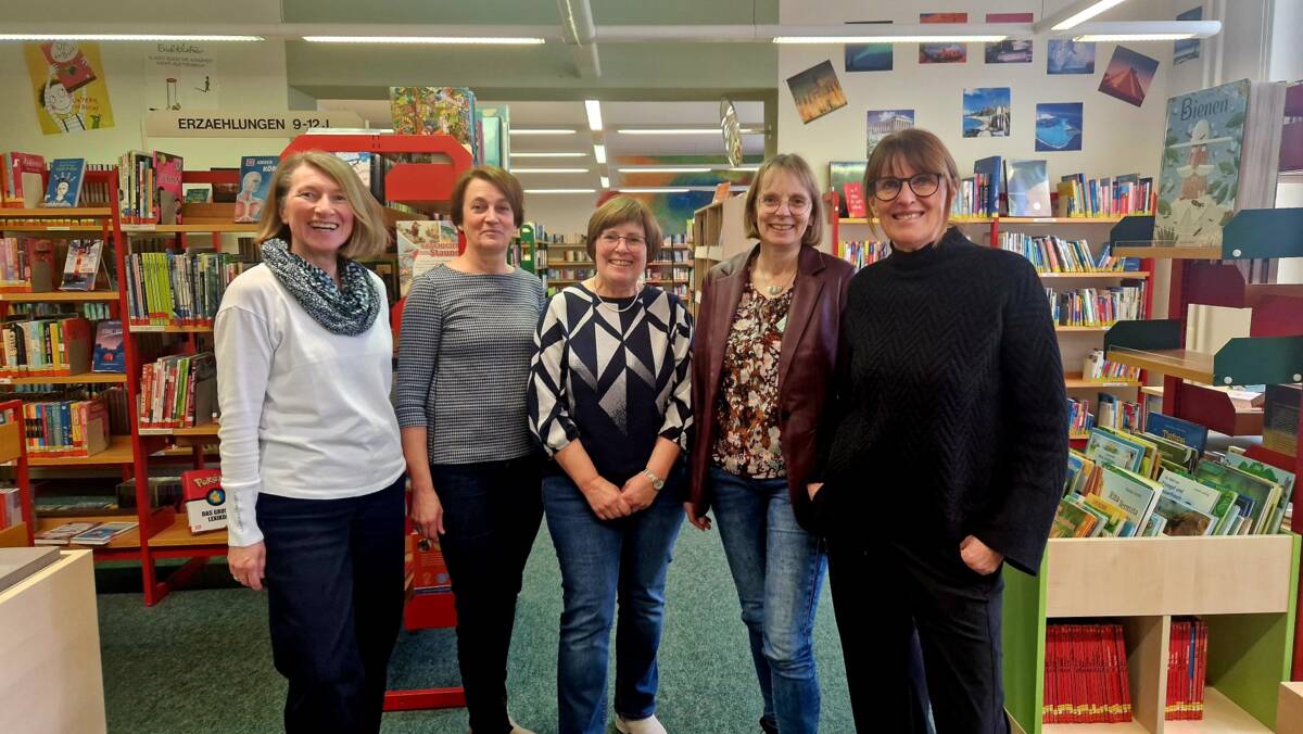 Dieses Bild zeigt die Mitarbeiterinnen der Stadtbücherei vor den Bücherregalen.